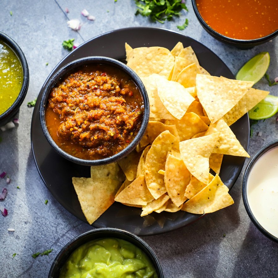 Golden tortilla chips beside a bowl of roasted salsa.